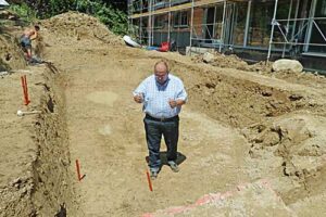 Rutengänger misst Wasseradern auf einer Baustelle